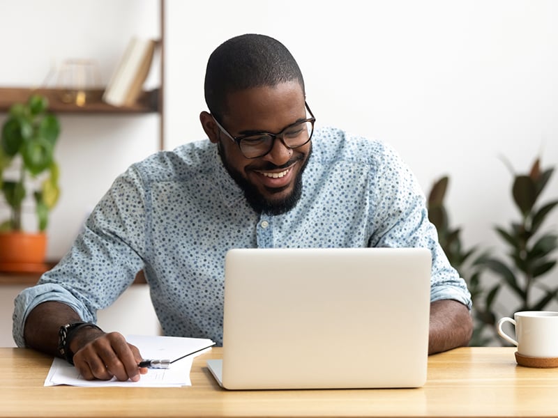 Smiling employee working on a laptop in an office