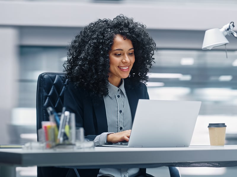 Businesswoman sitting at her desk working on a laptop