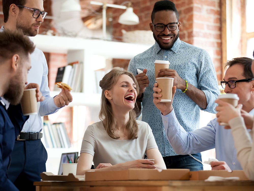 Happy group of colleagues take a lunch and coffee break in an office