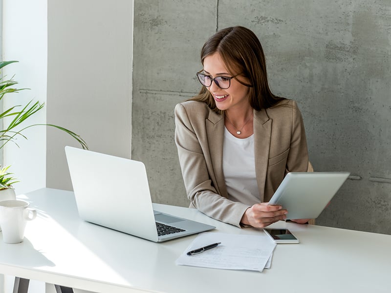 Professional executive woman working with multiple devices